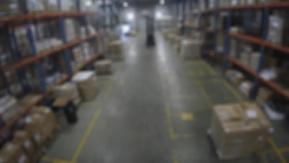 Blur degradation in a warehouse aisle CCTV view, with pallet racks and lane markings visibly unfocused.