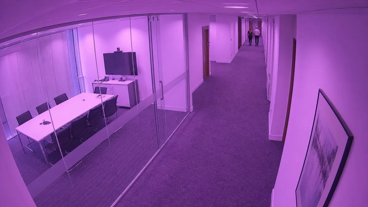 Colour cast degradation in an office corridor CCTV view with an abnormal magenta tint.