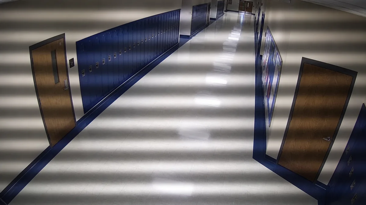 Flicker degradation in a hallway CCTV view with broad horizontal light bands.